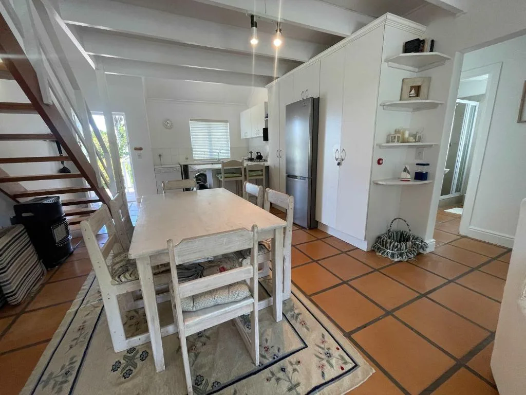 Modern white kitchen with stainless steel fridge and dining table