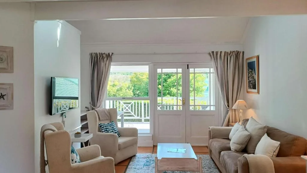 Spacious lounge with comfortable seating and doors opening to deck view