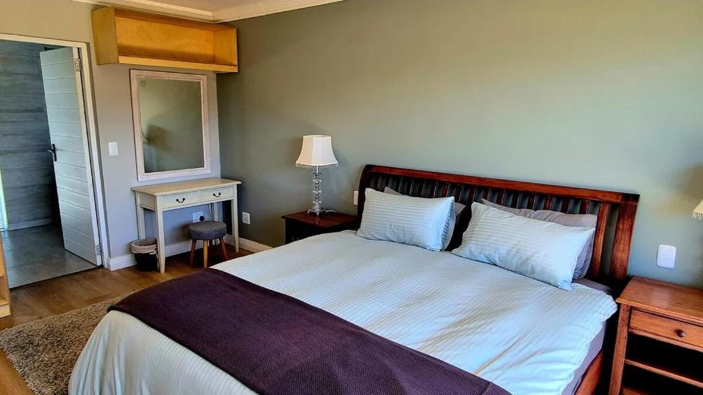 Spacious bedroom with wooden bed frame and crisp white linens