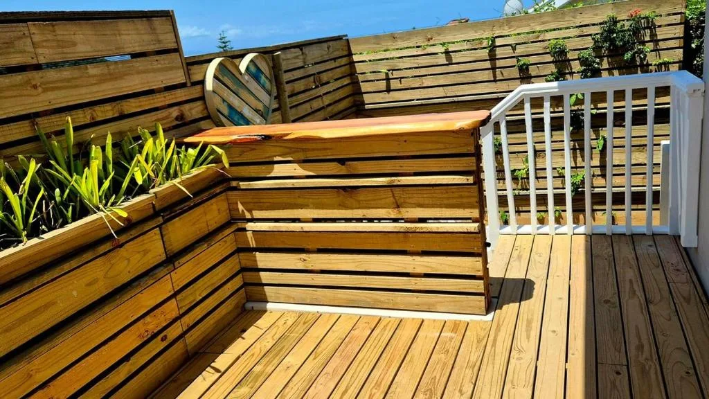 Wooden deck with planters, seating, and white lattice privacy screen