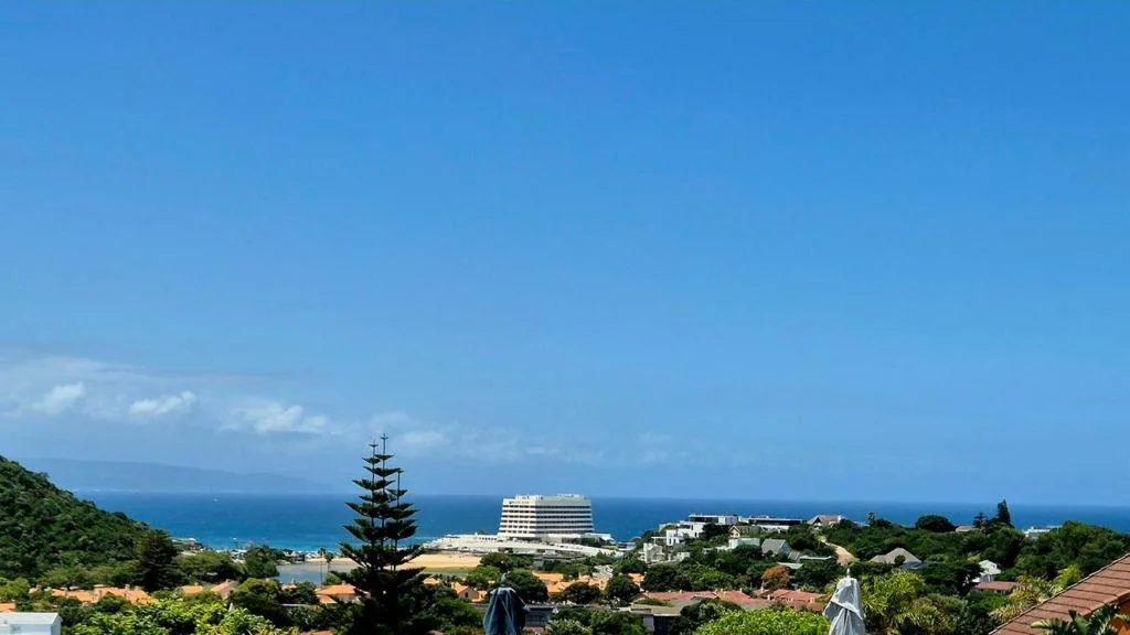 Panoramic coastal view of Plettenberg Bay with ocean and distant buildings