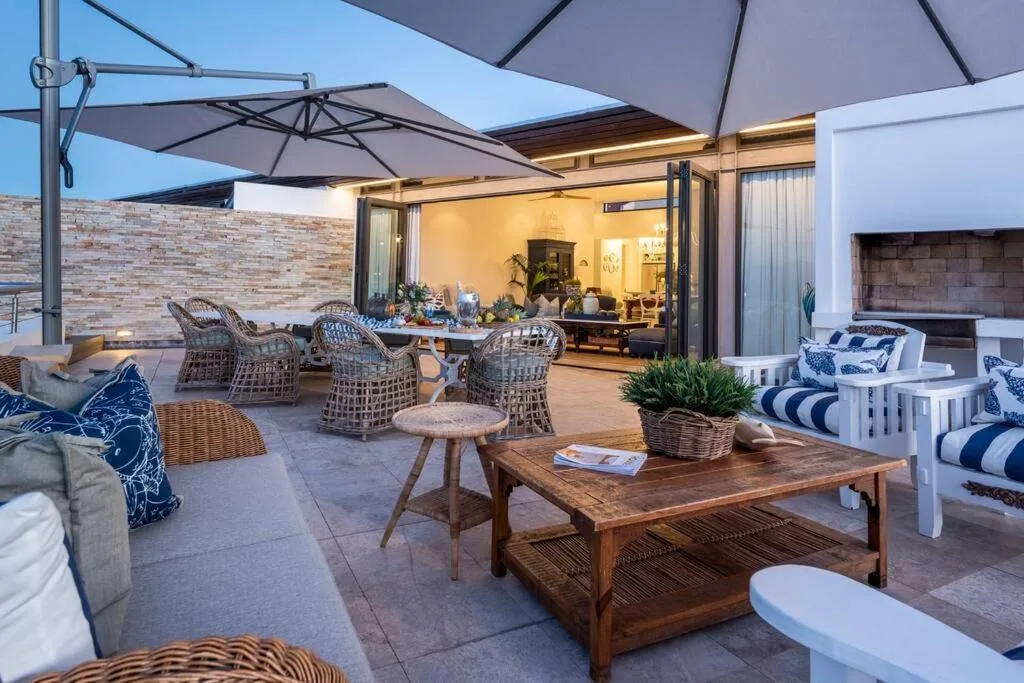 Spacious outdoor deck with shade umbrellas, wicker seating, and ocean views