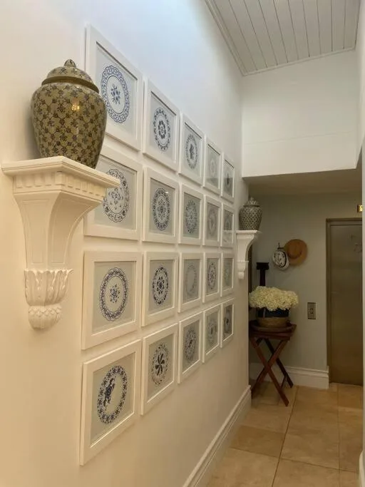 Decorative wall gallery with blue and white plates and ceramic vessels