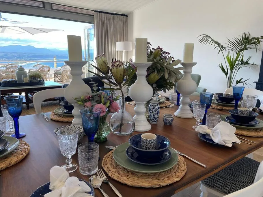 Elegantly set dining table with mountain and ocean views through windows