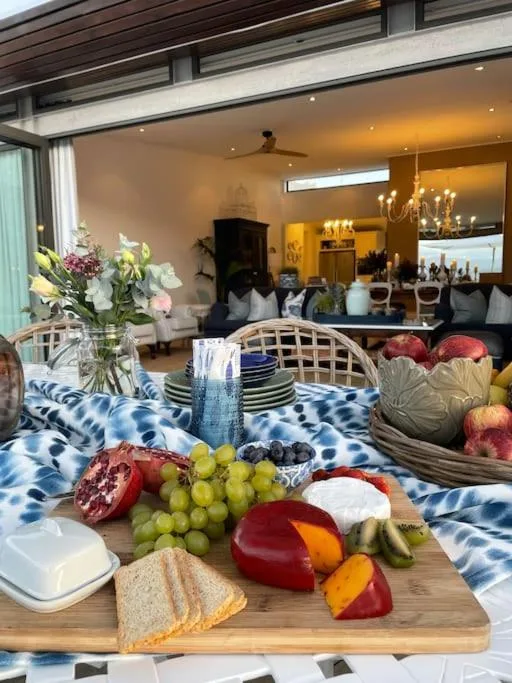 Dining table with fresh fruit and bread, open-plan lounge beyond