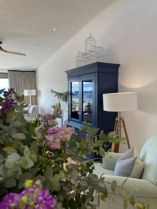 Bright living room with blue cabinet, flowers, and seating area