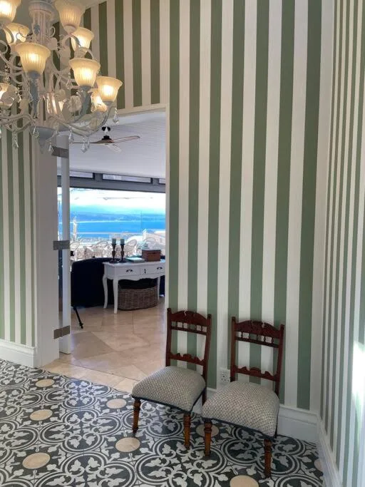 Ocean vista through elegant interior with striped walls and coastal scenery beyond