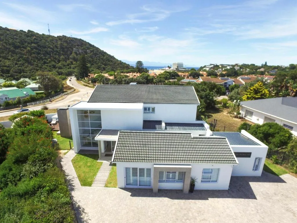 Modern white villa with dark roof overlooking Plettenberg Bay and surrounding landscape