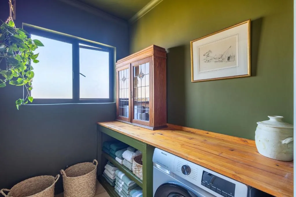 Utility room with washing machine, wooden counter, and storage shelves