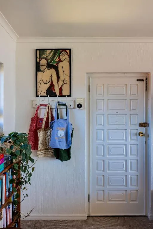 Interior wall with artwork, backpacks, and decorative elements near door