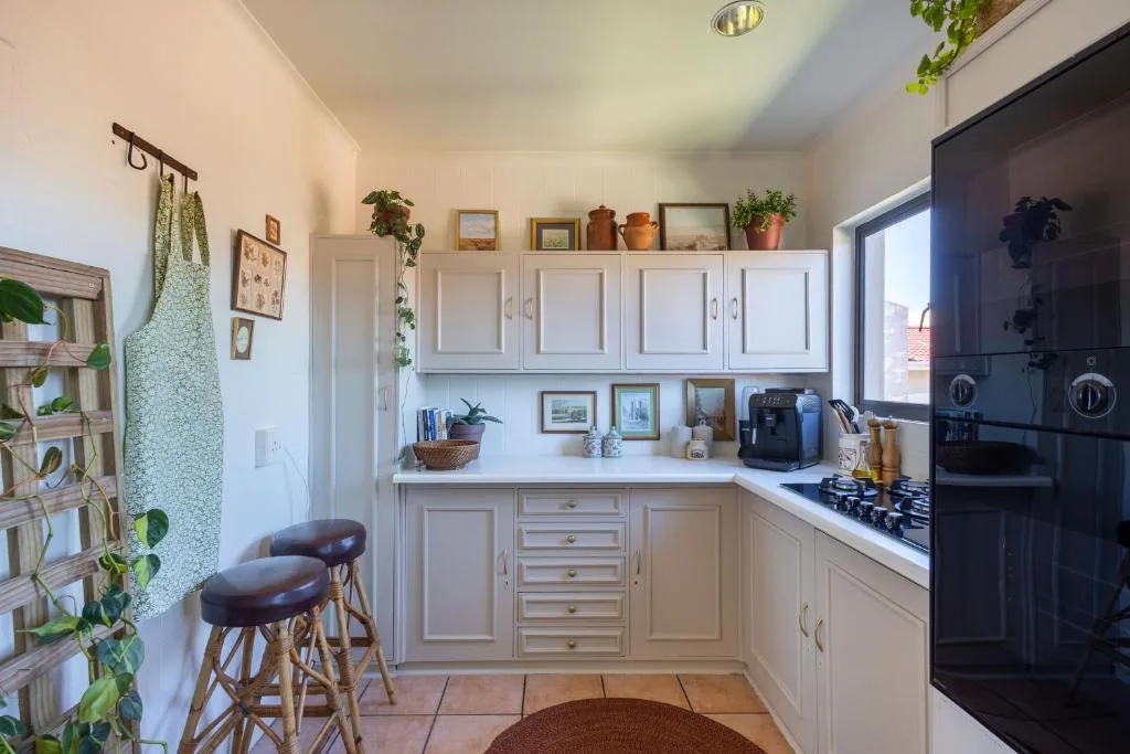 Bright kitchen with white cabinetry, gas cooktop, and bar seating for two