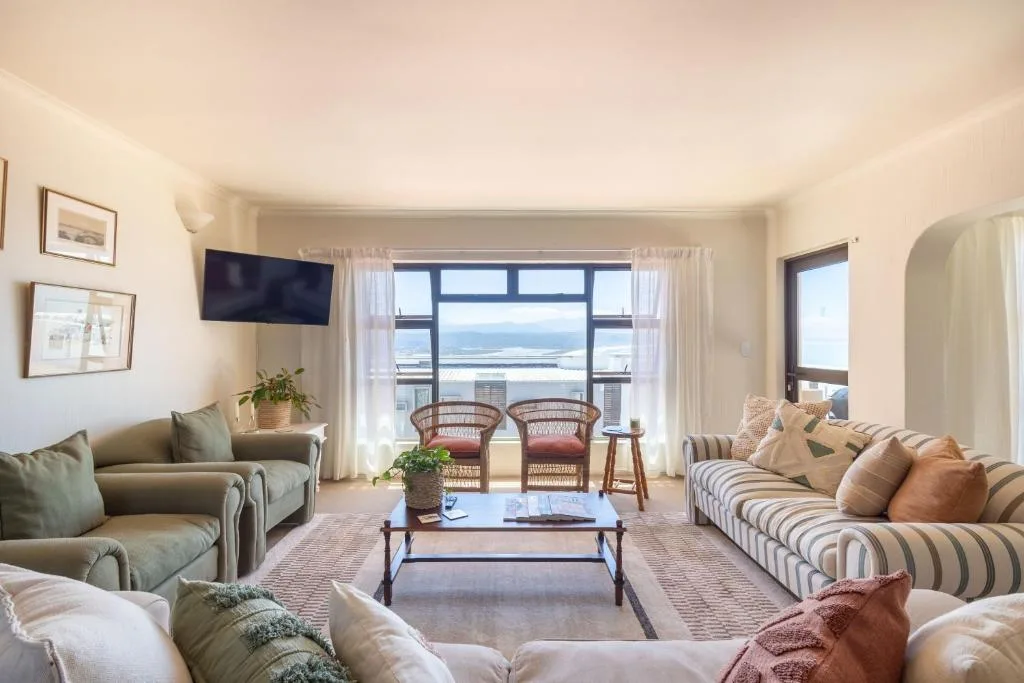 Bright lounge with multiple sofas facing ocean views through large windows