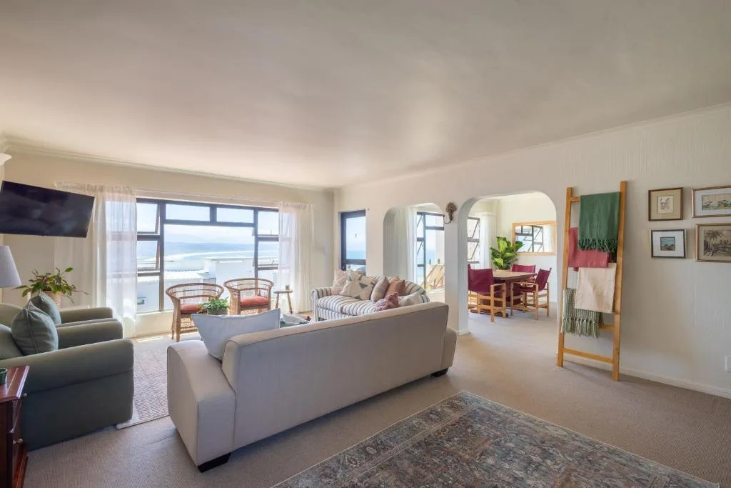 Spacious lounge with ocean views, comfortable seating, and coastal decor