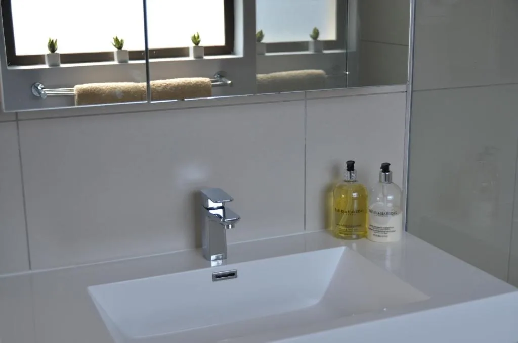 Modern bathroom sink with chrome faucet and amenity bottles