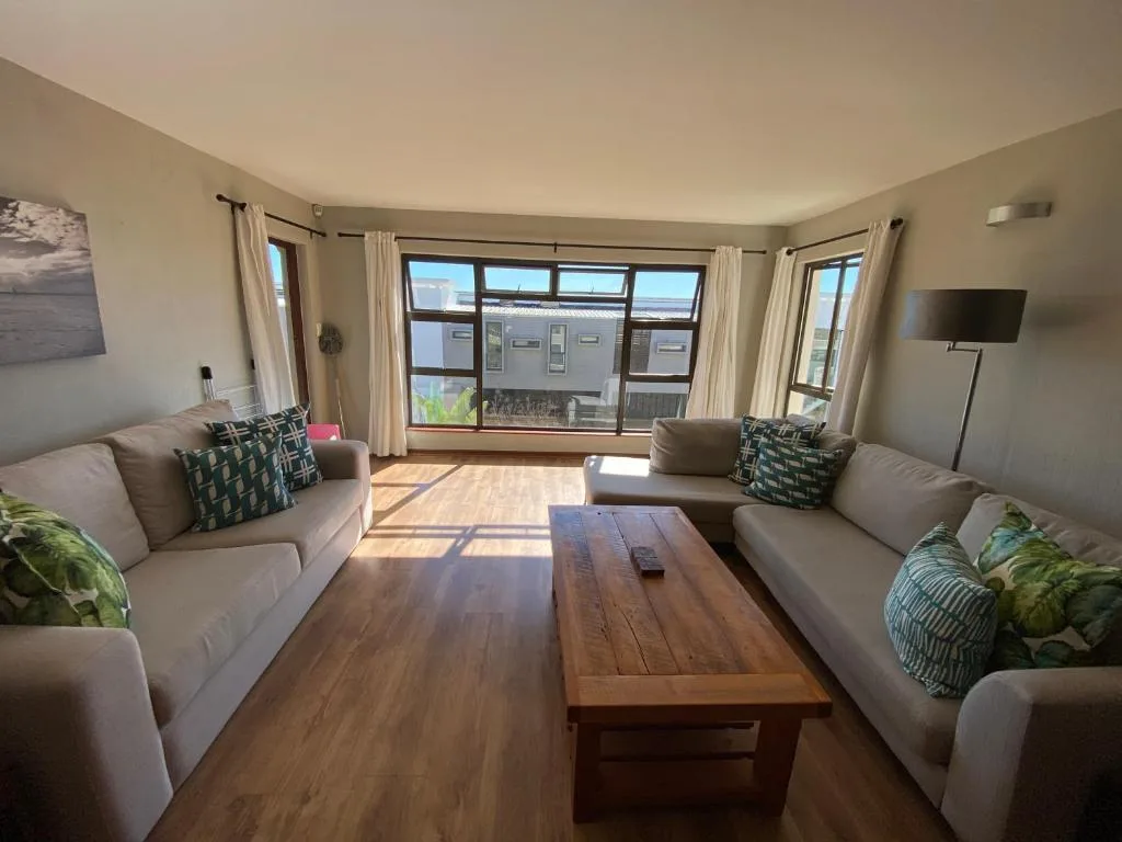 Spacious living room with two beige sofas and wooden coffee table