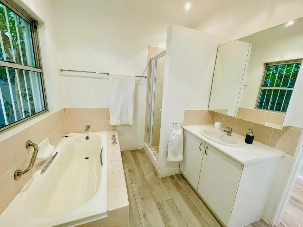Spacious bathroom with bathtub, shower enclosure, dual vanity sink