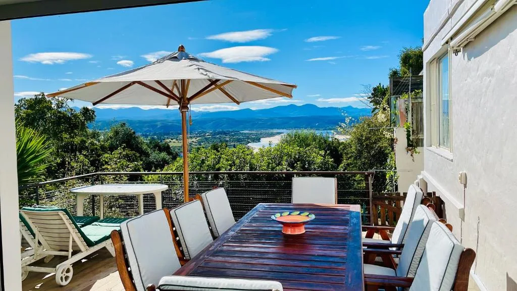 Elevated deck with dining table, umbrella, and panoramic mountain valley views