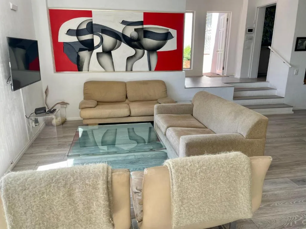 Spacious lounge with neutral sofas, modern art, and contemporary furnishings