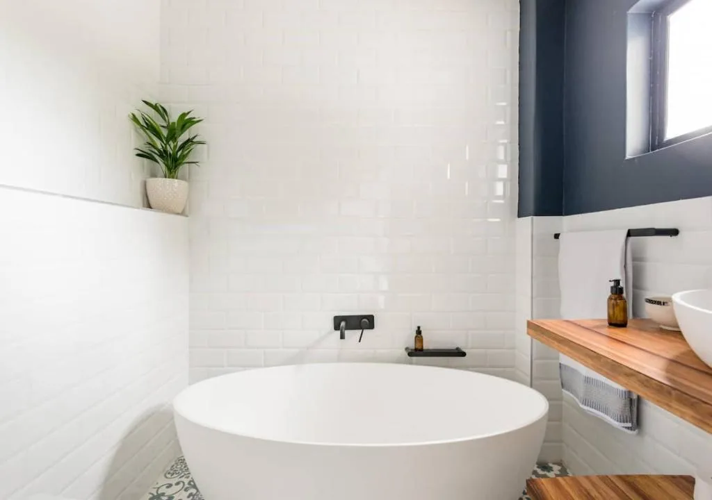 Modern bathroom with freestanding white bathtub and wooden vanity