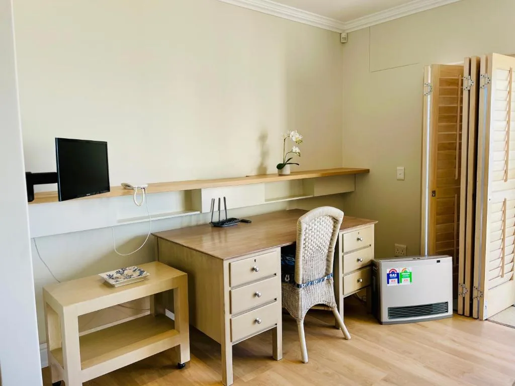 Bright bedroom workspace with desk, chair, and wall-mounted shelving