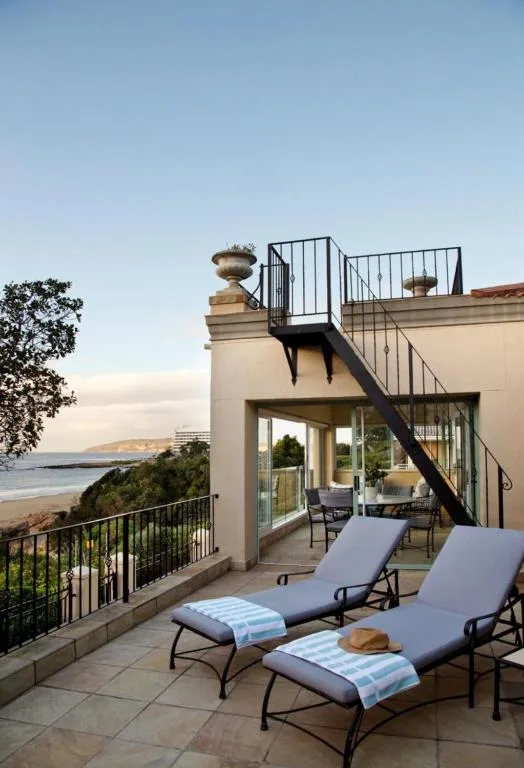 Coastal deck with loungers overlooking beach and ocean views