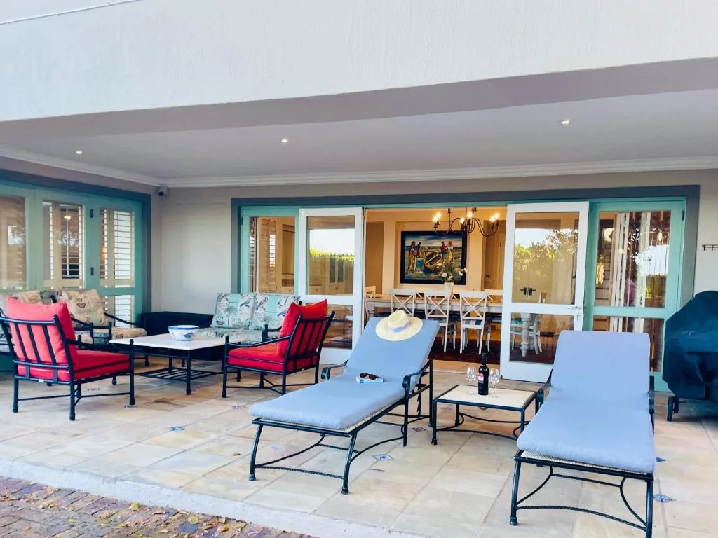 Spacious patio with lounge chairs, seating area, and turquoise glass doors