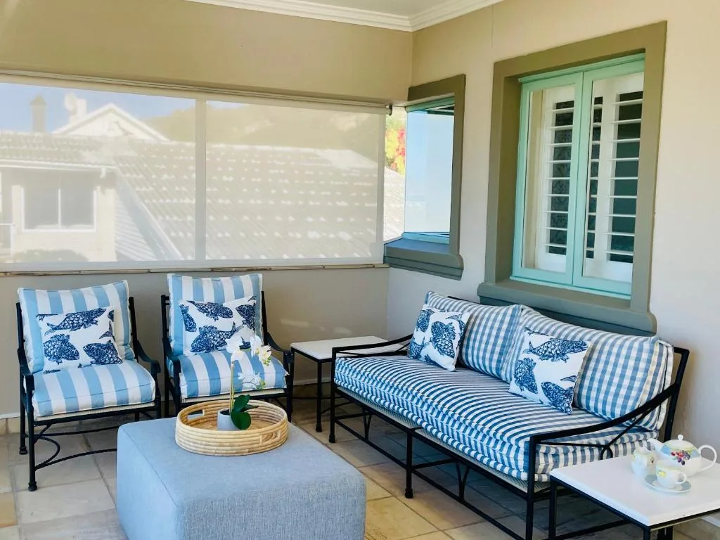 Covered patio with striped furniture and ocean view doors