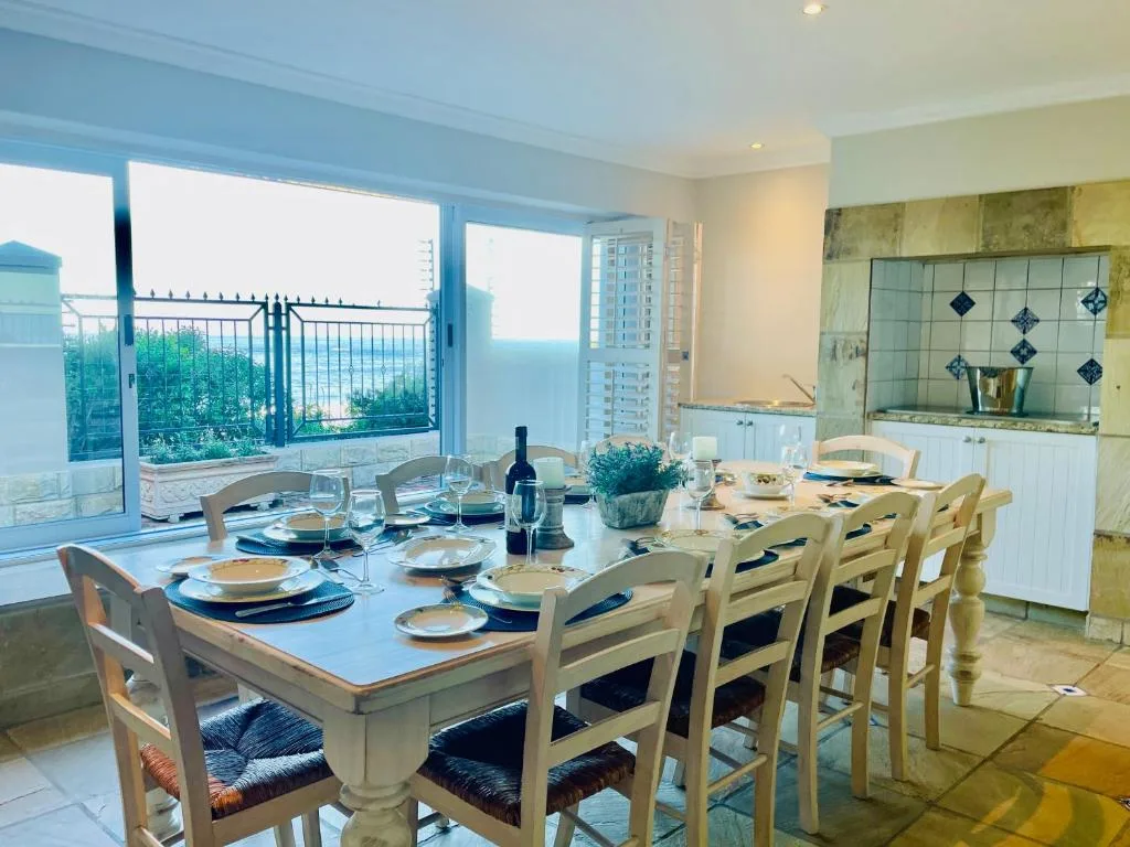 Elegant dining room with ocean view through large windows and set table