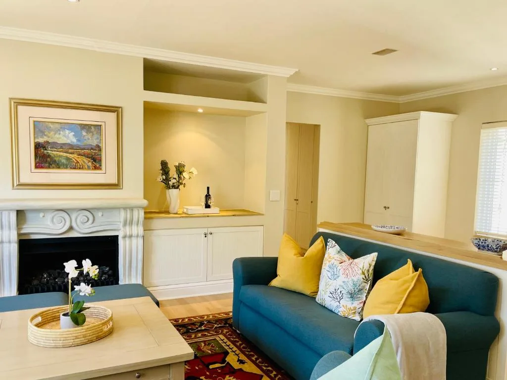 Cream-colored living room with teal sofa, fireplace, and built-in shelving
