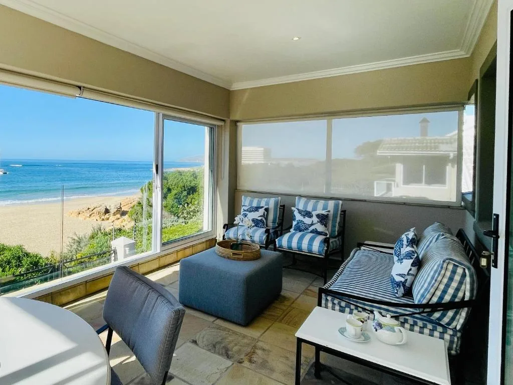 Bright lounge with ocean views, comfortable seating, and blue striped furnishings