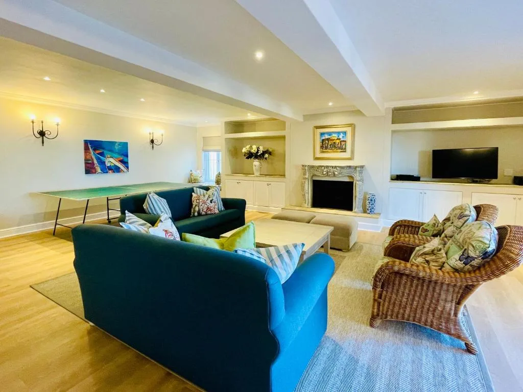 Spacious open lounge with blue sofas, fireplace, and entertainment area