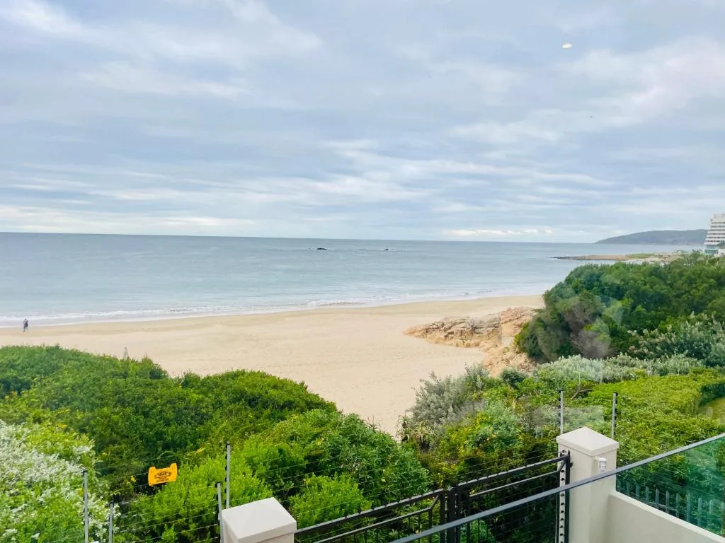 Sandy beach and ocean horizon viewed from property deck railing