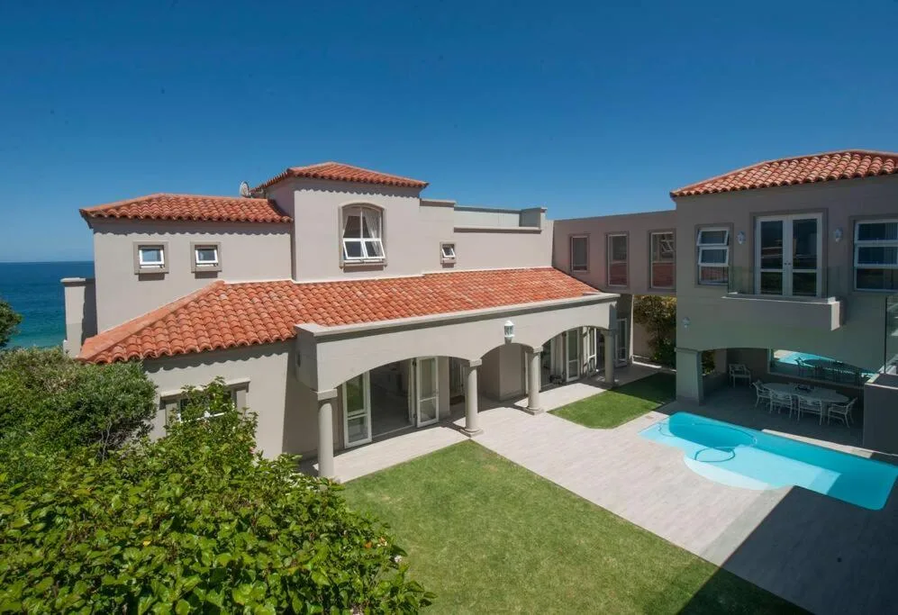 Mediterranean-style villa with terracotta roof, ocean view, and pool area
