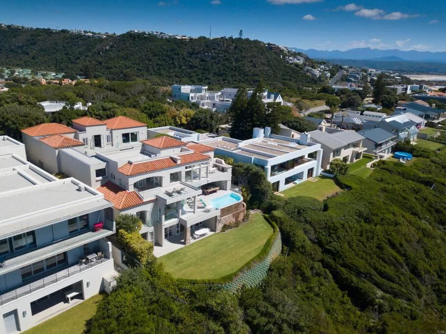Modern villa with pool nestled in lush hillside garden overlooking valley