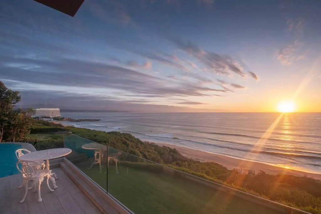 Sunset over ocean and beach from elevated coastal property deck