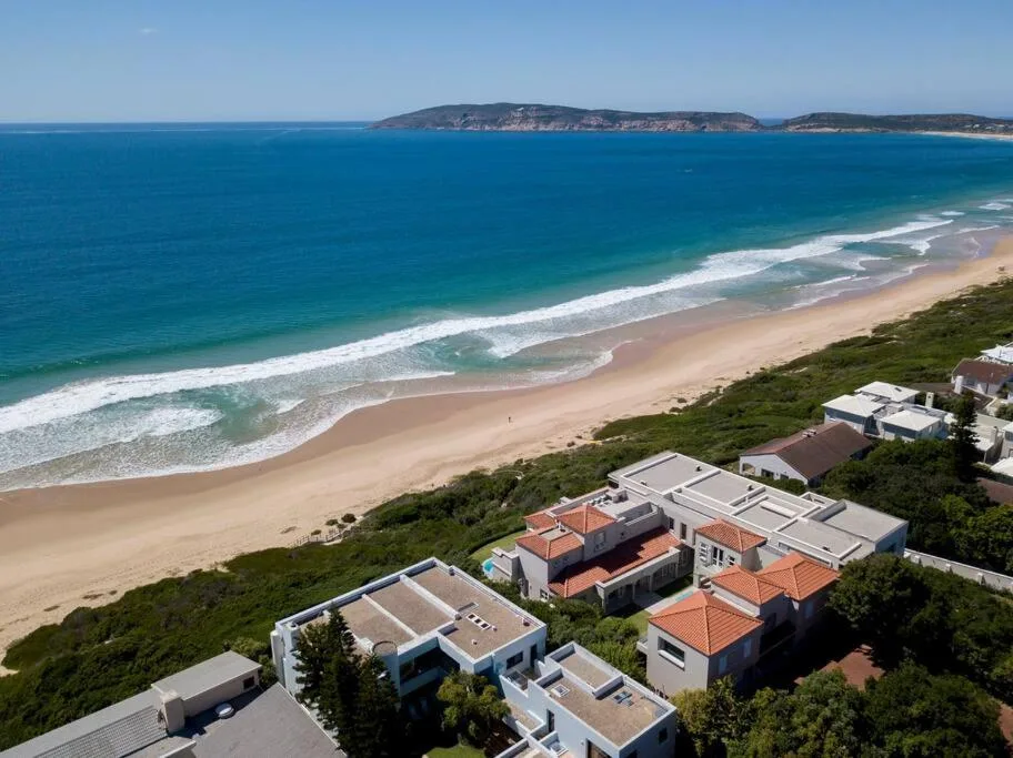 Stunning panoramic view of pristine beach, turquoise ocean, and distant cliffs