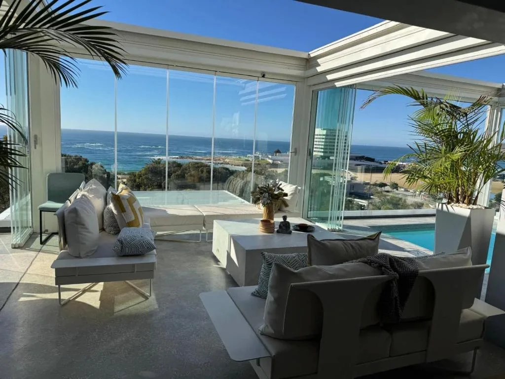 Spacious outdoor patio with seating, pool, and panoramic ocean views