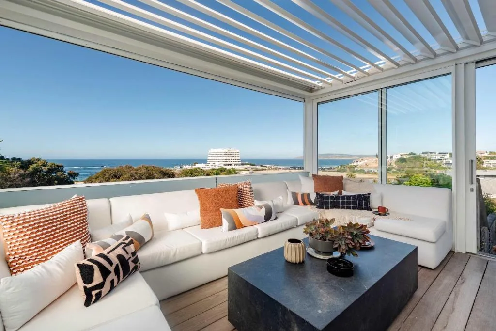 Modern outdoor seating area with ocean and coastal views from deck