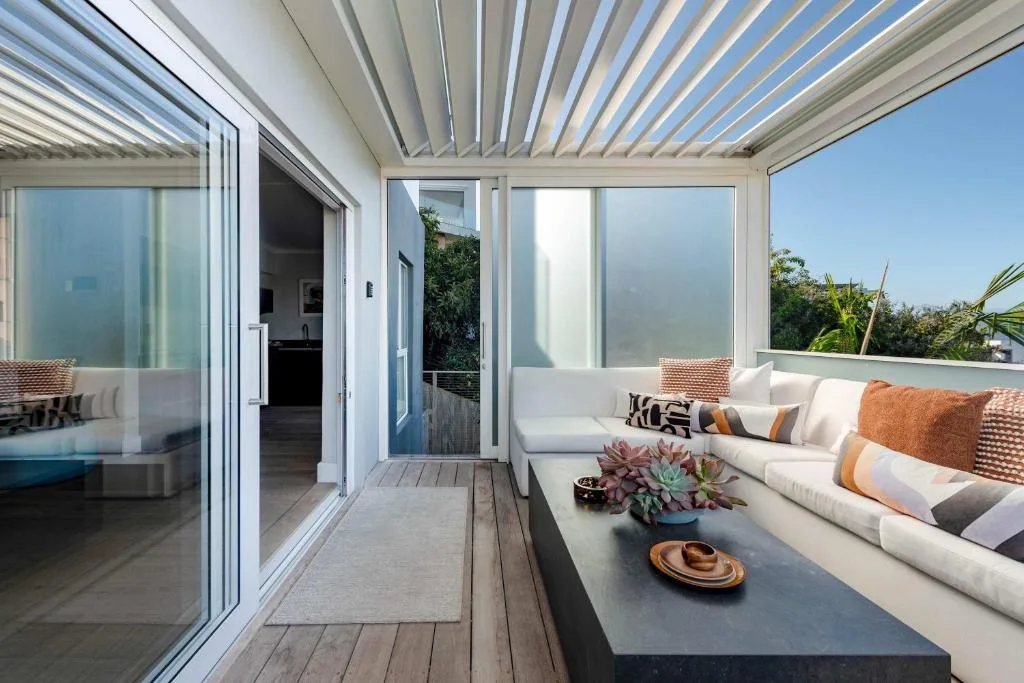 Modern covered deck with lounge seating, succulent plants, and ocean views