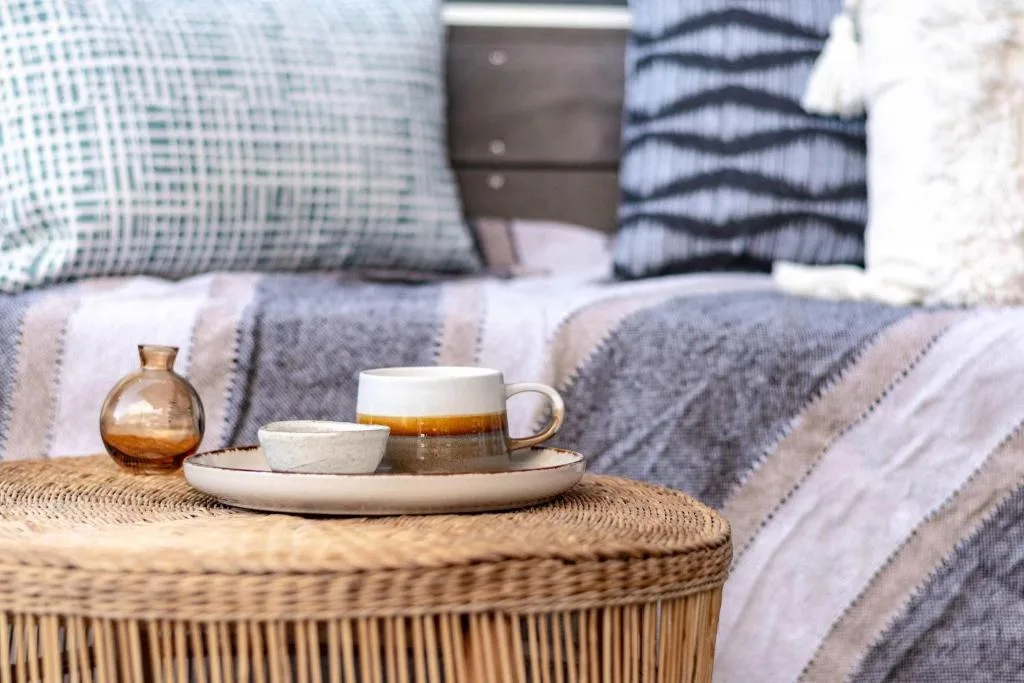 Styled bedside table with tea service and amber glass decor