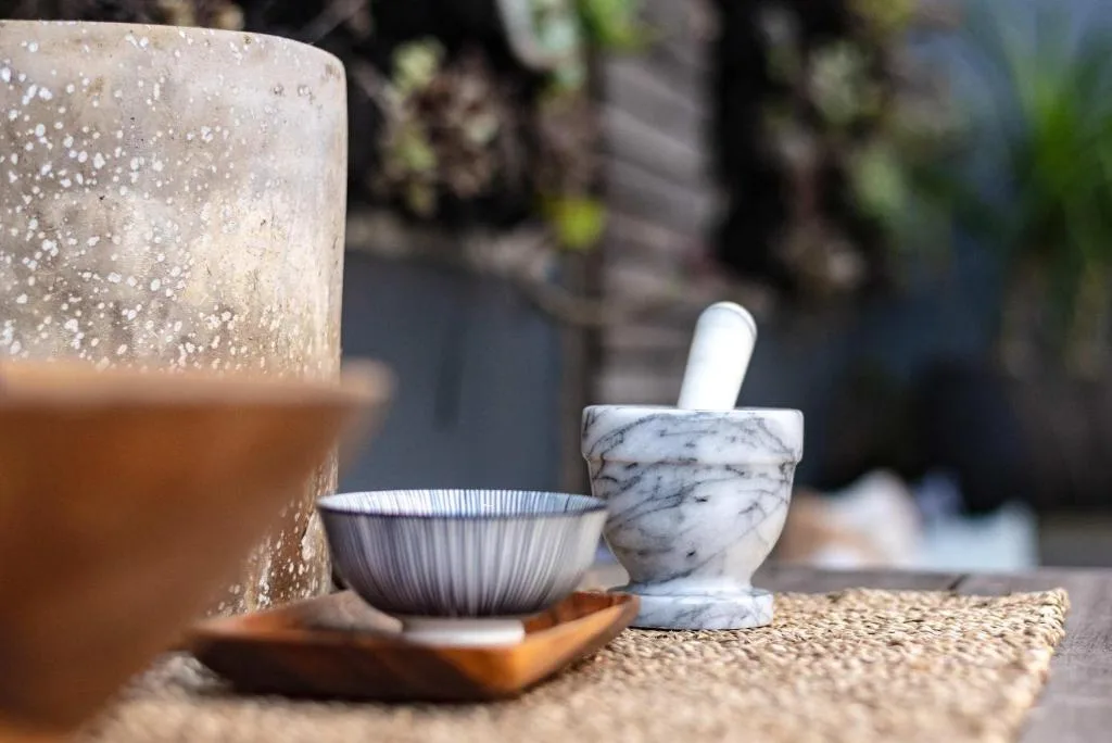 Decorative mortar and pestle with ceramic bowl on outdoor surface