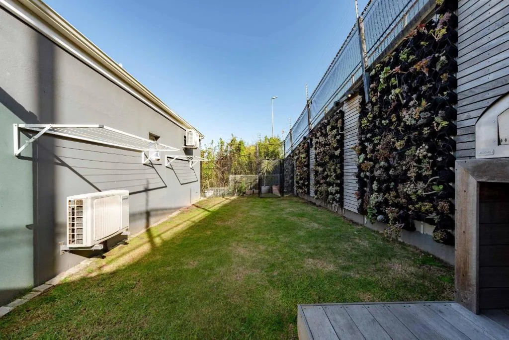 Modern villa with manicured lawn, living walls, and contemporary architecture