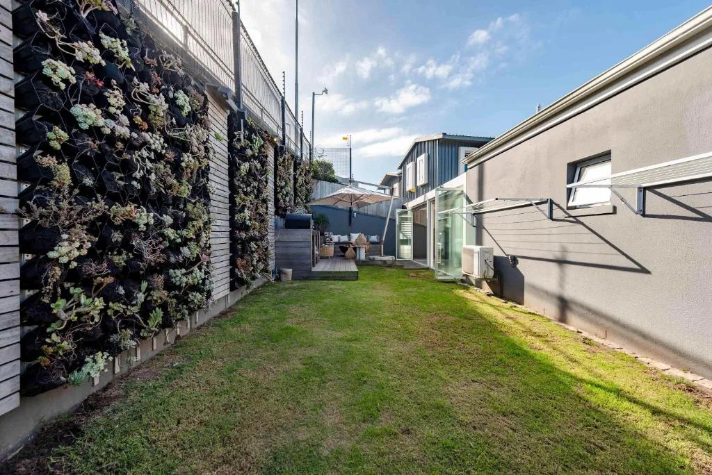 Modern villa garden with living wall and manicured lawn