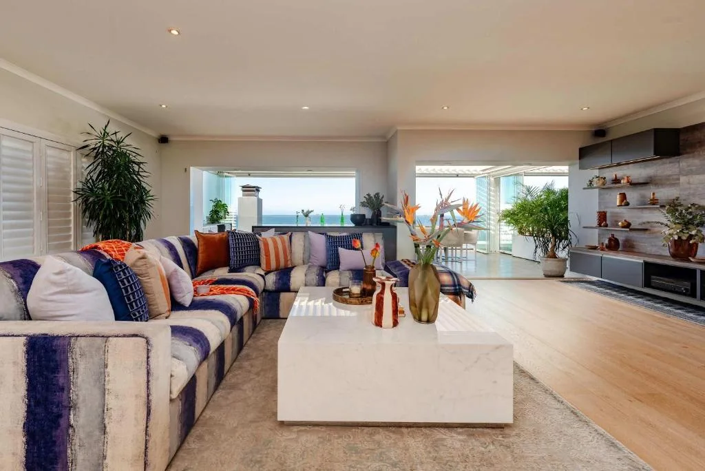 Modern lounge with striped sofa, ocean views, and contemporary decor