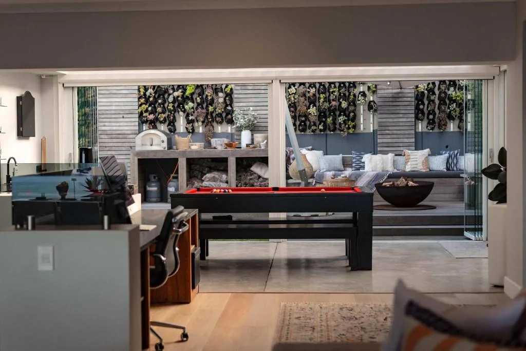 Open-plan lounge with pool table and sliding glass doors to deck