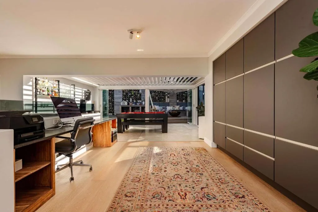 Modern lounge with desk area, billiards table, and garden views