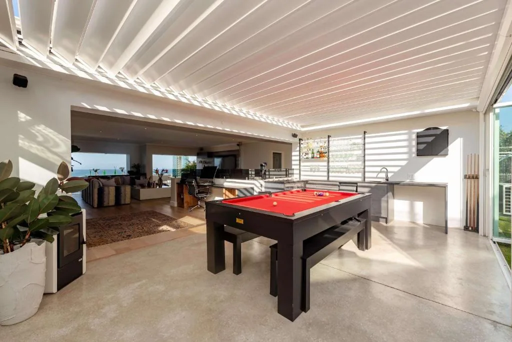 Modern open-plan lounge with pool table and ocean views