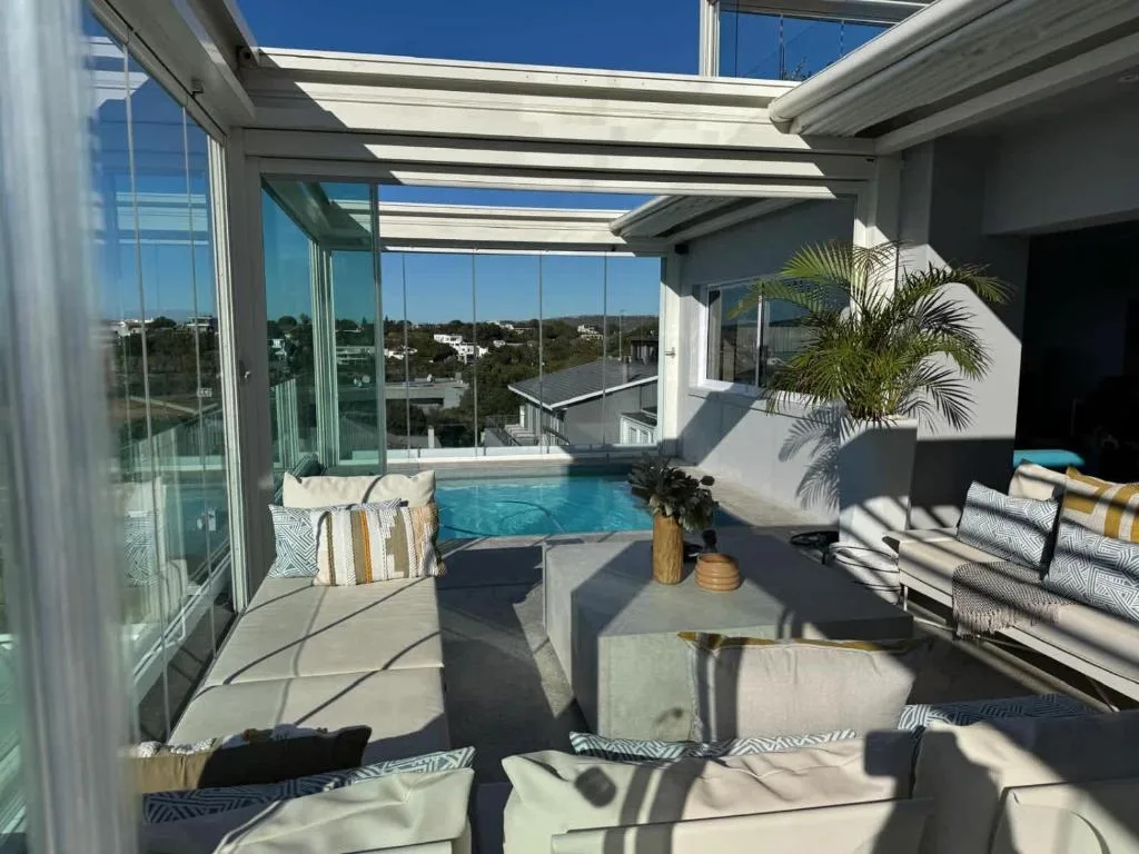 Indoor heated pool with lounge seating and panoramic views of Plettenberg Bay