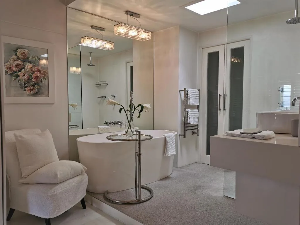 Luxury bathroom with freestanding tub, large mirror, walk-in shower enclosure