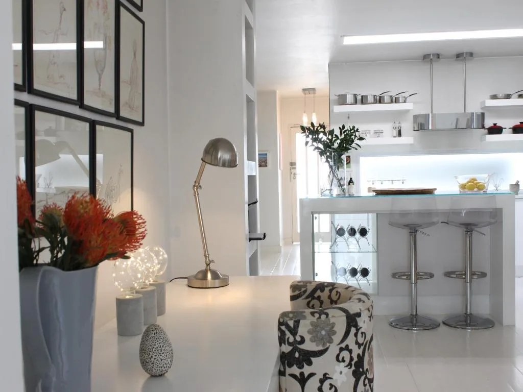 Modern kitchen counter with red flowers, desk lamp, and decorative accessories